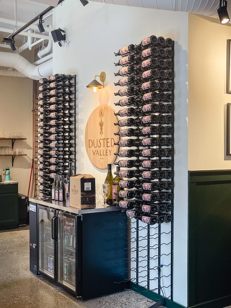 a wall of wine display on wall racks